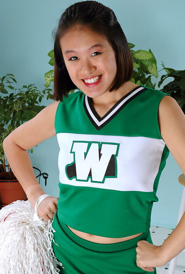 Amateur Asian freeing big tits and ass from beneath cheerleader uniform